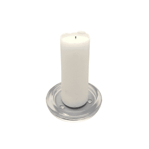 A white pillar candle rests on the Candle Coaster l Glass, a round clear glass coaster, set against a plain white background.