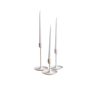 Three Taper Candles in minimalist white holders, set at different heights on a plain white background, create an elegant display.