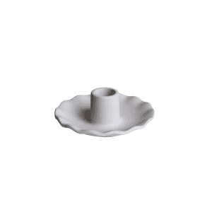 The Taper Candle Holder l Flower features a white ceramic design with a fluted edge and central opening, its elegant, flower inspired shape displayed against a plain white background.